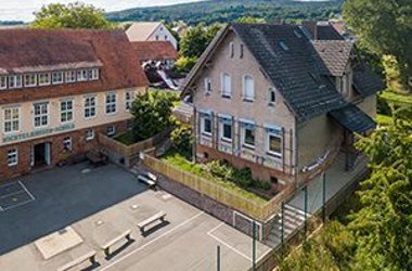 Zwei Schulgebäude mit Schulhof aus der Vogelpersepktive