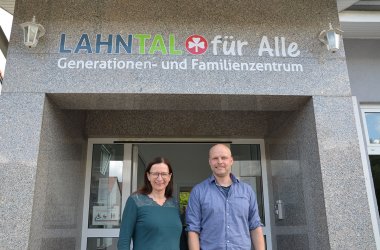 zwei Menschen vor gemeindegebäude